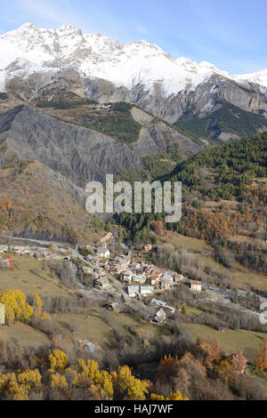 AERIAL VIEW. Village of Entraunes (1250m) at the foothill of Roche Grande Peak (2751m) in the Upper Var Valley. Alpes-Maritimes, France. Stock Photo