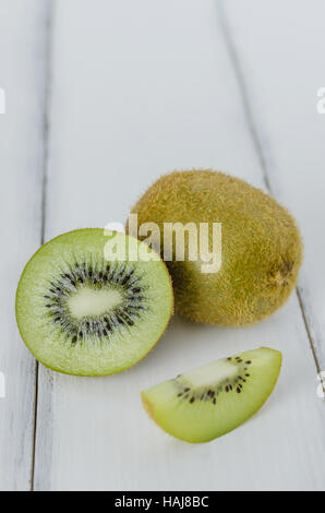 delicious whole kiwi fruit and sliced on wooden background Stock Photo