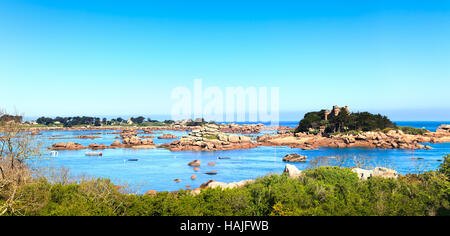 Ploumanach, rocks and bay beach in morning. Pink granite coast, Perros Guirec, Brittany, France. Stock Photo