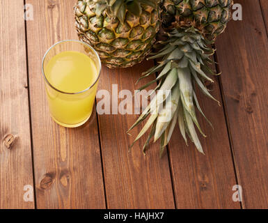 Raw whole pineapple on wooden surface table Stock Photo