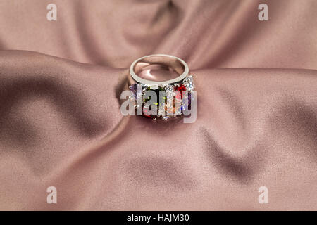 Precious ring with stones on satin brown background Stock Photo