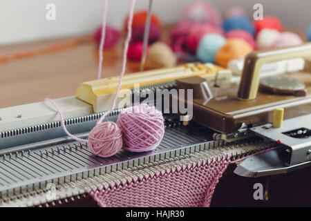 Hand Knitting Machine. A knitting machine is a device used to create knitted fabrics in a semi or fully automated fashion. Stock Photo