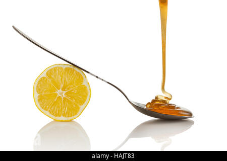 Lemon slice and honey flowing on spoon Stock Photo