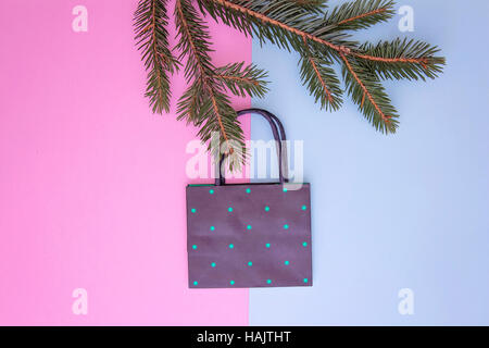 Frame of shopping bag hanging on the christmas tree twigs. Colourful background. Xmas shop, sale and gifts concept. Top view. Flat lay Stock Photo