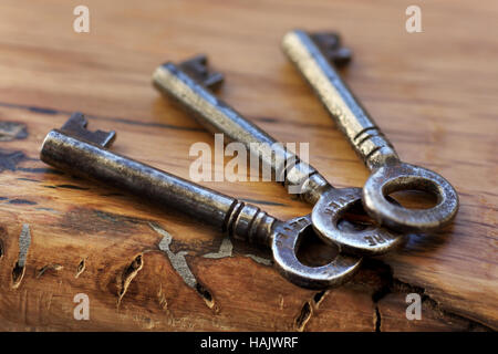 Three old keys found recently in a drawer, placed on a gnarled oak sill. Stock Photo