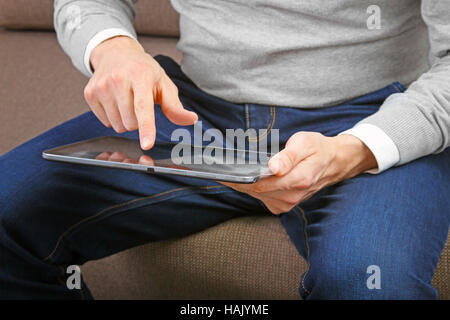 man using his finger to navigate on a digital tablet screen Stock Photo