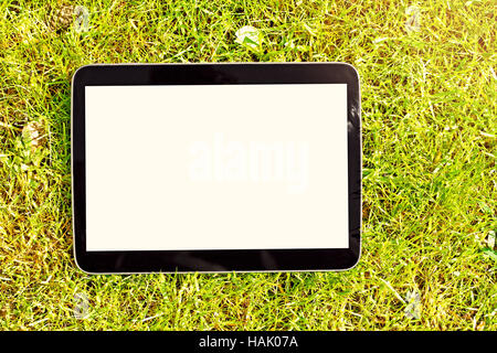 blank digital tablet lying on green grass Stock Photo