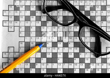 top view of blank crossword puzzle with black eyeglasses and a pen Stock Photo