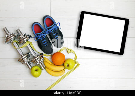 fitness equipment, fruits and blank digital tablet on white wooden floor