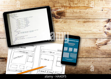 website wireframe sketch and programming code on digital tablet Stock Photo