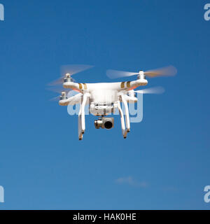 drone hovering against blue sky on sunny day Stock Photo