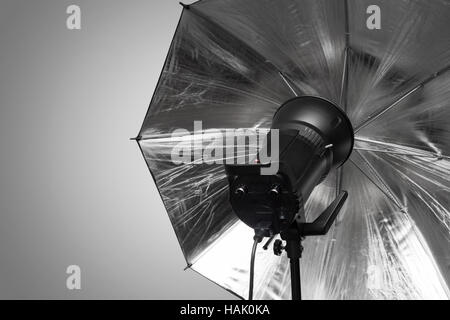 photography studio strobe flash with silver umbrella and gray copy space Stock Photo