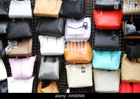 women handbags hanging on wall in store Stock Photo