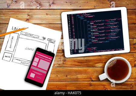 website wireframe sketch and programming code on digital tablet Stock Photo