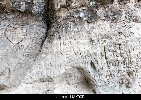 sandstone cliff wall with inscriptions Stock Photo