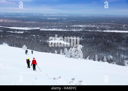 group of hikers in snowy winter mountains - Luosto, Finland Stock Photo