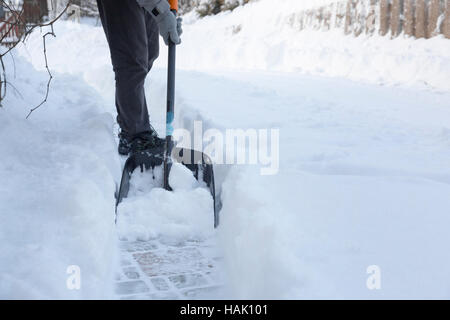 man shoveling snow away from walkway Stock Photo