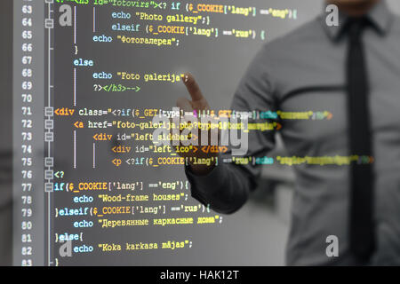 man pointing on virtual screen with website programming code Stock Photo