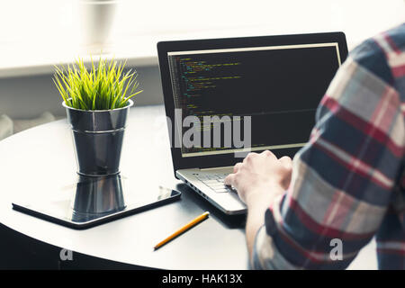 programmer working on laptop at office. focus on programming code Stock Photo