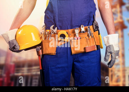 construction worker with tool belt at building site Stock Photo