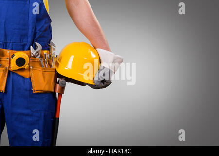 construction worker holding helmet on gray background with copy space Stock Photo