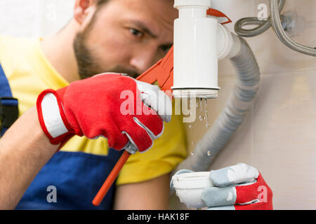 plumber fixing the sink siphon in a bathroom or kitchen Stock Photo