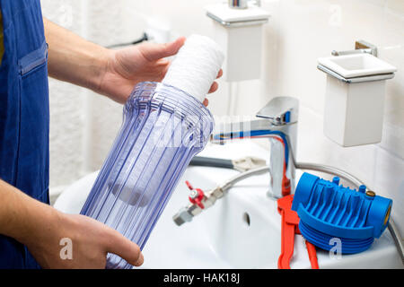 plumber installing new water filtration system Stock Photo