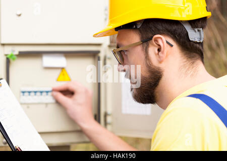 electrician checking fuse box Stock Photo