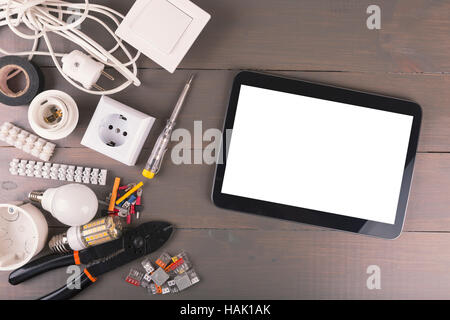 blank digital tablet with electrical tools and accessories on wooden table Stock Photo