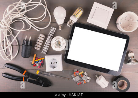 blank digital tablet with electrical tools and equipment on wooden table Stock Photo