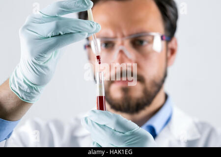 scientist analyzing blood test sample in laboratory Stock Photo
