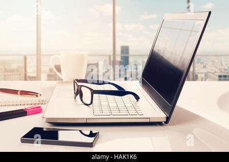 workplace with cityscape behind window Stock Photo