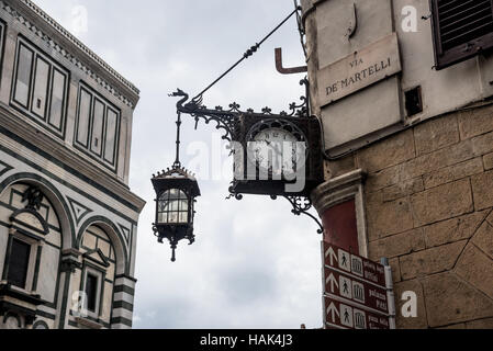 Medieval ornate street lamp and clock, Florence, capital of Tuscany region, Italy Stock Photo