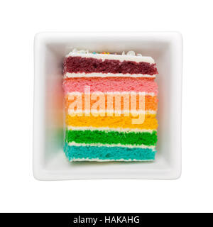 Slice of rainbow cake in a square bowl isolated on white background Stock Photo