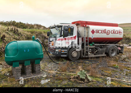 Domestic heating oil tank being filled from tanker truck, Ireland Stock Photo