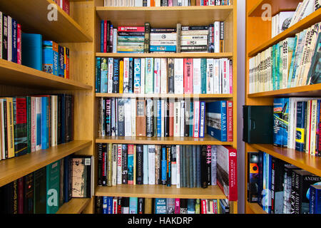 Book case with shelves of English books on military subjects, mainly second world war. Hardbacks and paperbacks mixed on various shelves. Stock Photo