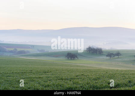 Countryside on Misty Morning at Dawn, Monchberg, Spessart, Bavaria, Germany Stock Photo