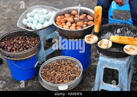 Vendors often cook and sell food such as corn, pastries and eggs along the roadway in some areas of China. Stock Photo