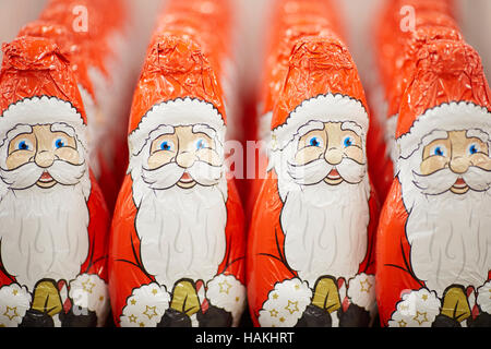 chocolate santa figures sweets   shop seasonal gift foil wrapped red coat hollow large on shelf caricature christmas treat shop retail selling store t Stock Photo