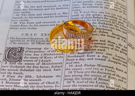 november 04 2016 Wedding rings place on an open Bible to a verse in the book of Genesis marriage. Stock Photo
