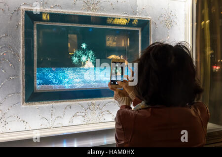 Woman photographing a Tiffany &  Co. window display on Fifth Avenue in New York City Stock Photo