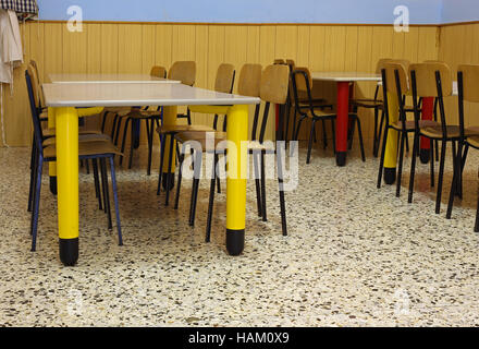 refectory tables and colored chairs in a nursery school Stock Photo