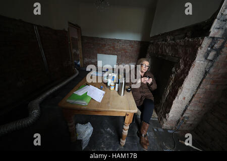 Pensioner Anne Reay from Warwick Road in Carlisle sits in the ruins of her home - one of hundreds of people facing another miserable festive season a year on from Storm Desmond. Stock Photo