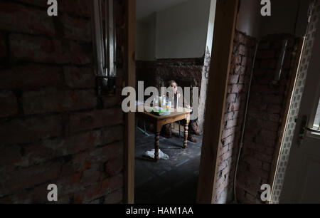 Pensioner Anne Reay from Warwick Road in Carlisle sits in the ruins of her home - one of hundreds of people facing another miserable festive season a year on from Storm Desmond. Stock Photo