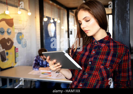 Smiling young women using digital tablet in the office. Stock Photo