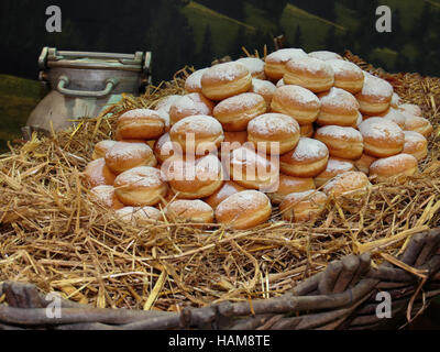 Heap of Fried Bavarian Cream Filled Donuts on Bed of Straw Stock Photo