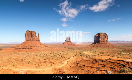 Monument Valley, West Mitten Butte, East Mitten Butte and Merrick Butte, dirt road in front, Navajo Nation, Arizona, USA Stock Photo