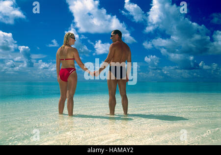 A couple standing in the ocean shallows, Summer Island Village, North Male Atoll, Maldives, Indian Ocean Stock Photo