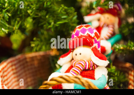 Old wooden toy with a red bow ribbon on Christmas Fir Tree Toys Burning Candles, Boxes, Balls, Pine Cones, Walnuts, Branchesin the background other decorations and garlands. copy space. Stock Photo