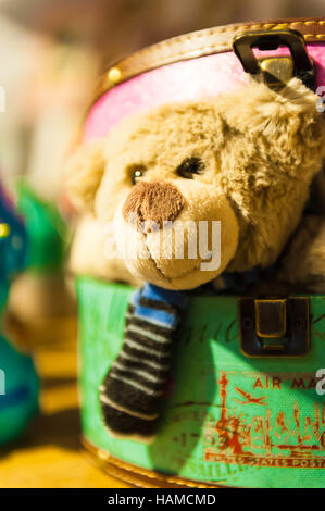 Teddy bear looks out from colorful boxes Stock Photo